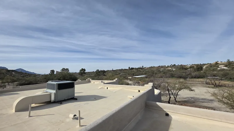 Finished flat roof coating on Tucson home with desert landscape