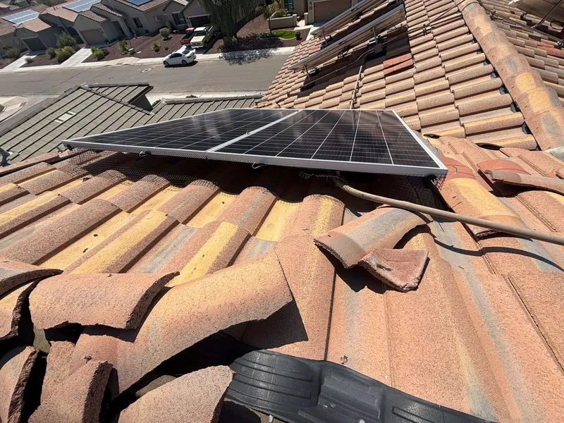 Storm-damaged tile roof with displaced tiles near solar panels in Tucson