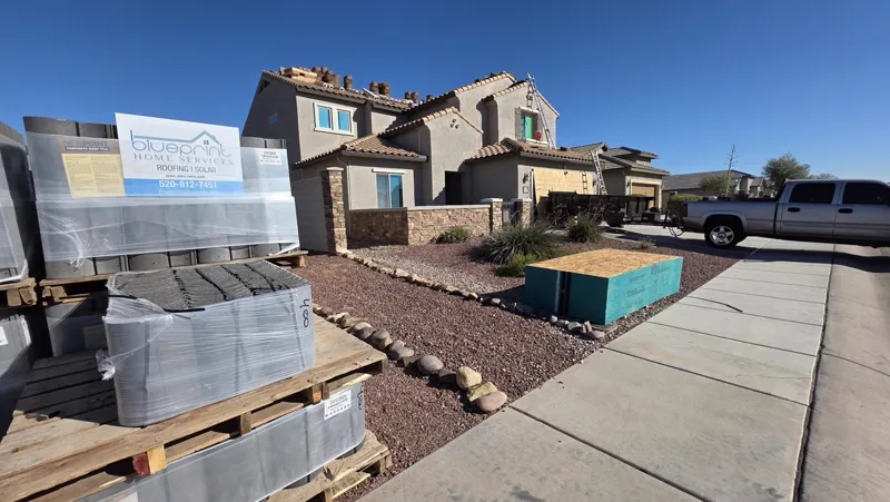 Blueprint Home Services roofing materials and branded signage at a Tucson jobsite